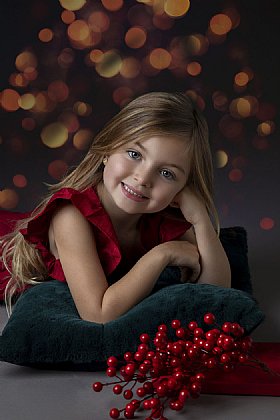 Kleines Mädchen liegt und lächelt in Kamera Portrait © Starmayr